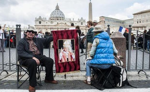 Des pèlerins sur la place Saint-Pierre de Rome au Vatican le 27 avril 2014, à l'occasion de la double canonisation des papes Jean XXIII et Jean-Paul II.