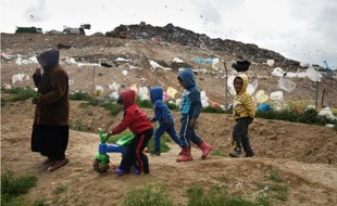 Des enfants de bédouins arabes israéliens jouent au pied de la décharge de Dudaim dans le sud d'Israël le 7 février 2016