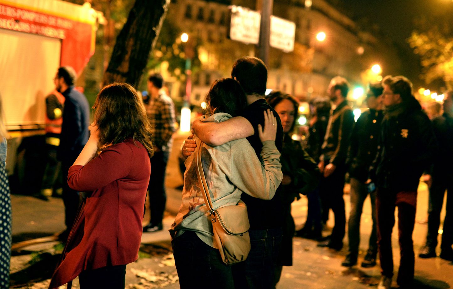 PARIS, FRANCE - NOVEMBER 13: Parisians look at the scene outside the Bataclan concert hall after an attack on November 13, 2015 in Paris, France. According to reports, over 120 people were killed in a series of bombings and shootings across Paris, including at a soccer game at the Stade de France and a concert at the Bataclan theater. (Photo by Pascal Le Segretain/Getty Images) (Photo by PASCAL LE SEGRETAIN / GETTY IMAGES EUROPE / Getty Images via AFP)