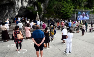 Des pèlerins devant la grotte de Massabielle, à Lourdes, le 30 mai 2020.