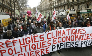Des manifestants défilent à Paris pour soutenir migrants et travailleurs sans papiers, à l'appel de plusieurs syndicats et associations, le 19 décembre 2015