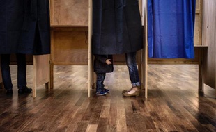 Des Français dans des isoloirs, dans un bureau de vote lyonnais