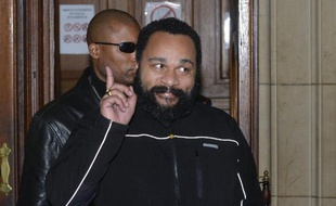 L'humoriste Dieudonné fait un signe à la sortie de l'audience du tribunal correctionnel de Paris où il est poursuivi pour apologie du terrorisme, le 4 février 2015