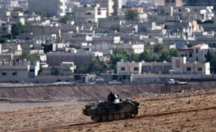 Des soldats turcs patrouillent à Mursitpinar, en face de la ville syrienne de Kobané où les combats continuent entre les forces kurdes et les jihadistes de l'EI, le 16 octobre 2014