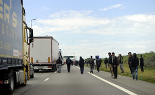 Illustration de migrants tentant de s'introduire dans les camions en direction de la Grande-Bretagne.