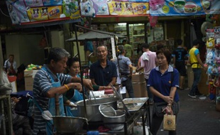 Un vendeur prépare à manger dans une allée du quartier chinois de Bangkok, le 12 avril 2016