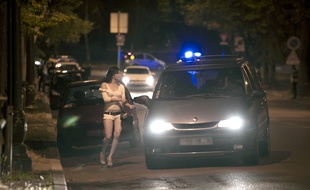 Paris, le 6 juin 2011. Une prostituée parle avec le chauffeur d'une voiture aux abords du Bois de Boulogne.