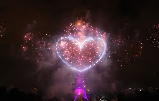 Des feux d’artifice illuminent la tour Eiffel tandis que des drones forment un cœur dans le ciel, lors d’un spectacle chorégraphié pour célébrer la Fête nationale, à Paris, le 14 juillet 2025.