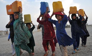 Des jeunes filles vivant dans un camp de déplacés vont chercher de l'eau avec des bidons, en 2013 dans la région de Nangarhâr (est de l'Afghanistan)