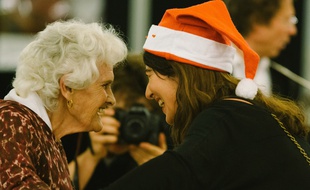 Une bénévole et une participante d'un réveillon de Noël organisé par Les petits frères des pauvres.