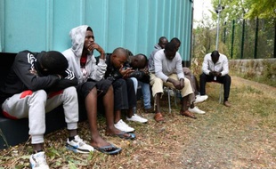 Des migrants attendent devant le site de Emmaus près de Paris et réclament de meilleures conditions d'hébergement, le 4 août 2015