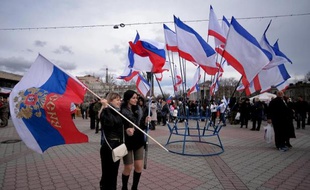 Deux femmes tiennent un drapeau russe (G) sur la place Lenine à Simferopol le 16 mars 2014