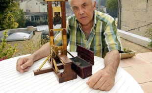A file picture taken on September 20, 2002, shows France's last surviving executioner in Algeria Fernand Meyssonnier showing the miniature replica of a guillotine in Fontaine-de-Vaucluse, southern France. He made this replica at the age of 15 as a present for his father who was chief executioner and inducted his son as an apprentice in 1947. AFP PHOTO GERARD JULIEN