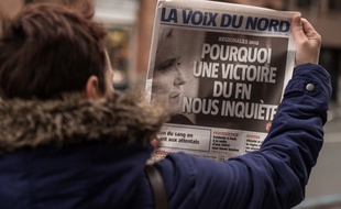 Une femme lit la Une de «La Voix du Nord» du 30 novembre 2015. AFP PHOTO / PHILIPPE HUGUEN
