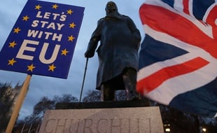 (190115) -- LONDON, Jan. 15, 2019 (Xinhua) -- Protesters hold a flag and a placard outside the Houses of Parliament, in front of a statue of Winston Churchill, in London, Britain on Jan. 15. 2019. The British parliament on Tuesday rejected overwhelmingly the Brexit deal, further complicating the country's historic exit from the European Union (EU).