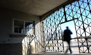 Un visiteur emprunte le portail d'entrée de l'ancien camp de concentration de Dachau en Allemagne dont la porte qui portait le slogan nazi "Arbeit macht frei" (le travail rend libre) a été dérobée, le 3 novembre 2014