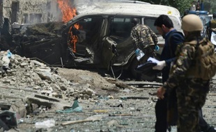 Des forces de sécurité afghanes sont sur le lieu d'un attentat contre un véhicule de l'OTAN à Kaboul, le 7 juillet 2015