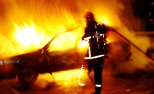 Un pompier intervient sur un incendie de voiture. Illustration.