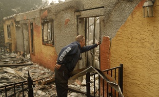 Un habitant inspecte la maison de son voisin, ravagée par les flammes à Paradise, en Californie, le 10 novembre 2018.