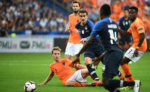 Frenkie de Jong, à terre, et Antoine Griezmann dans les airs.