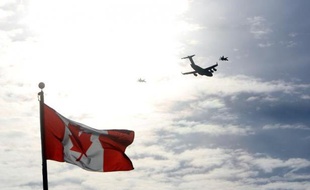 Un avion volant au dessus du drapeau du Canada, à Ottawa le 18 mars 2014