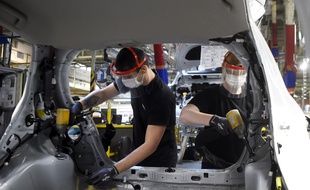 Des salariés de Toyota portent des masques de protection et des gants sur une ligne d'assemblage automobile, à Onnaing, près de Valenciennes, le 23 avril 2020.