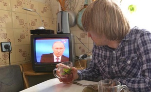 Un habitant de Stavropol regarde le président russe Vladimir Poutine tenir à Moscou, le 16 avril 2015, sa séance annuelle de questions-réponses en direct à la télévision