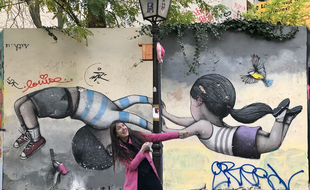 Stephanie Chenavier, fondatrice de Explorhappy, devant une oeuvre de Seth Haute.