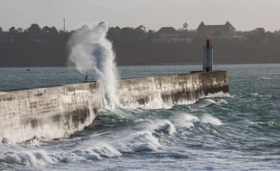 Illustration de vagues s'éclatant sur une digue à Saint-Malo.