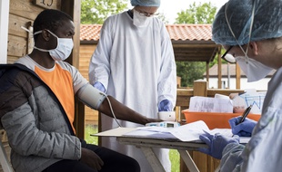 Un médecin et une infirmière examinent un migrant atteint par le Covid-19 le 2 mai près de Nantes, en France.