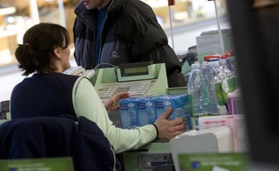 Une femme, caissière dans un supermarché.
