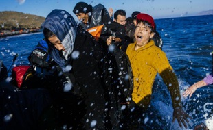 Des migrants et des réfugiés arrivent sur la plage de Lesbos en Grèce, après avoir traversé la mer Égée au départ de la Turquie, le 15 octobre 2015