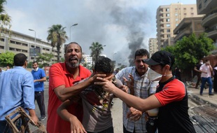Au Caire, des partisans de Morsi fuient les gaz lacrymogènes, le 14 août 2013.