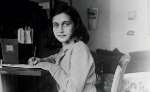 Photo d'archive d'Anne Frank rédigeant son journal, dans sa maison à Amsterdam