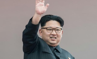Le leader nord-coréen Kim Jong-Un salue depuis le balcon dominant l'immense Place-Kim-Il-Sung à la fin d'un gigantesque défilé marquant la fin la fin du congrès exceptionnel du parti unique le 10 mai 2016