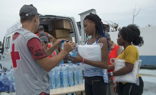 Un membre de la Croix-Rouge distribue de l'eau à des sinistrésn le 21 septembre 2017 à Saint-Martin. AFP PHOTO / Helene Valenzuela