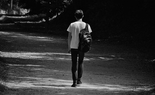 Un jeune homme seul sur une route