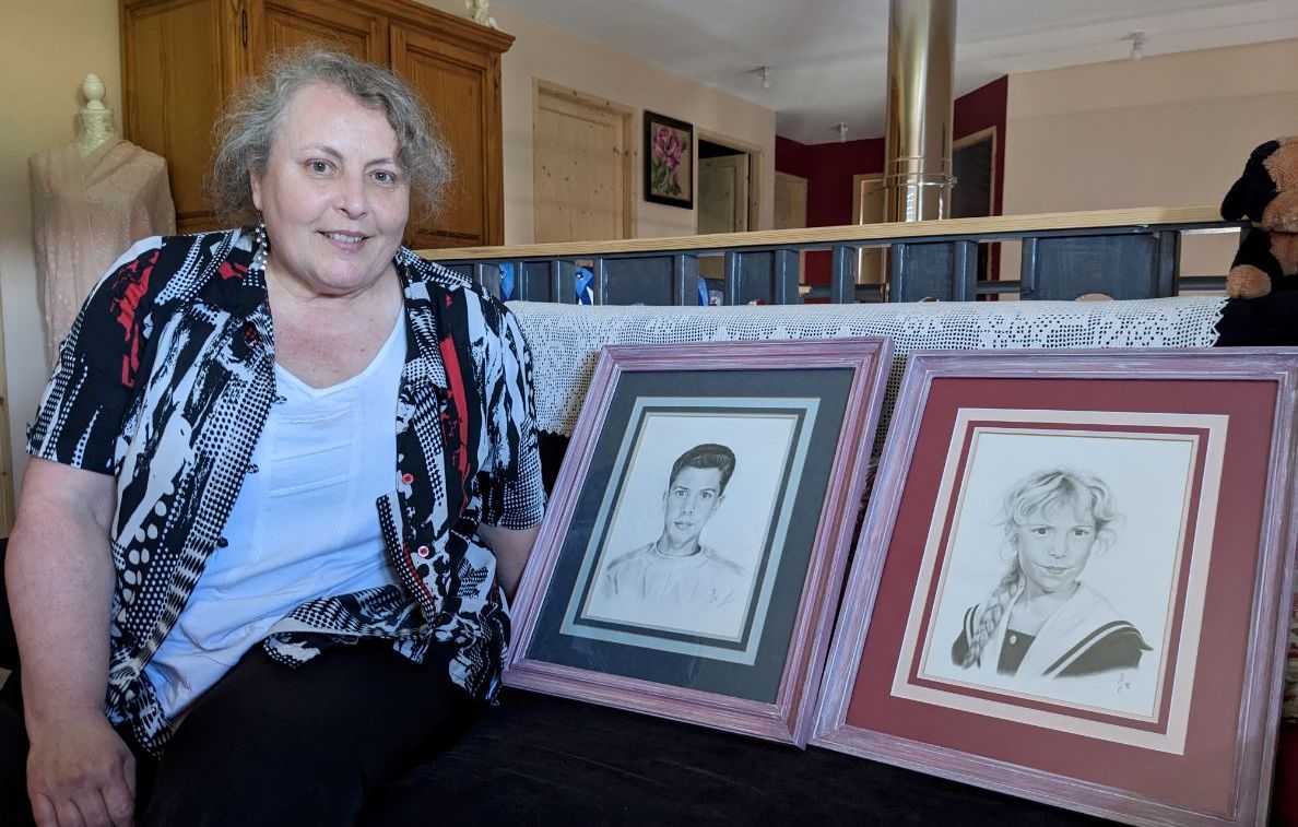 Carole Rognon pose avec les portraits de ses deux enfants, Christophe et Hélène, tués par leur père le 1er janvier 1996.