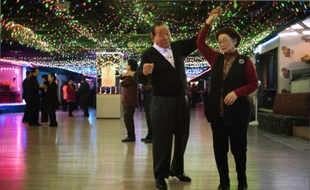 Un couple de retraités danse sur la piste d'une "Colatec", discothèque réservée au troisième âge, à Séoul le 2 décembre 2015