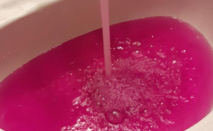 L'eau rose de Onaway sortant du robinet ludni