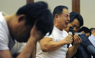 Des proches des passagers du vol MH370 de la Malaysia Airlines le 21 avril 2014 à Pékin