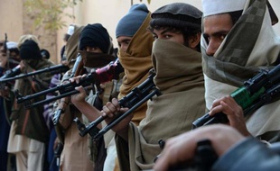 Des anciens combattants talibans afghans tiennent leurs armes avant de les rendre lors d'un processus gouvernemental de paix et réconciliation, le 8 février 2015 à Jalalabad