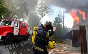 Des services de secours interviennent à Donetsk, en Ukraine, le 5 octobre 2014, dans une maison touchée par un obus