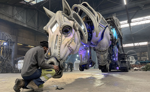 Un ouvrier travaille sur un buste de cheval animé, à la halle Spada