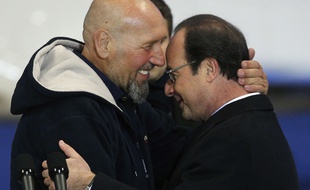 France's Serge Lazarevic, left, hugs French President Francois Hollande after he arrived at Villacoublay's military airport, west of Paris, Wednesday, Dec. 10, 2014. France's last hostage was freed Tuesday after being held for more than three years by al-Qaida's North Africa branch Û rekindling debate over whether countries should negotiate with extremists or stick to a muscular, uncompromising policy that runs the risk of a beheading or a botched rescue attempt. (AP Photo/Christophe Ena)/PAR123/687143867821/1412101000