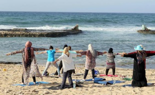 Des femmes libyennes participent à une séance de yoga sur une plage de Tripoli, le 14 avril 2016
