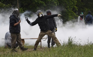 Un zadiste renvoyant une cartouche de gaz lacrymogène en direction des forces de l'ordre à Notre-Dame-des-Landes le 17 mai 2018.