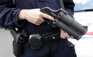 Un policier tient un flash-ball