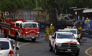Des pompiers mexicains à côté d'un camion incendié le 1er mai 2015 à Guadalajara par des groupes à l'origine d'une vague de violences dans l'Etat de Jalisco