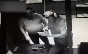 Capture d'écran de la vidéosurveillance d'un stand de tir américain montrant un homme se tirer par accident une balle dans la main.